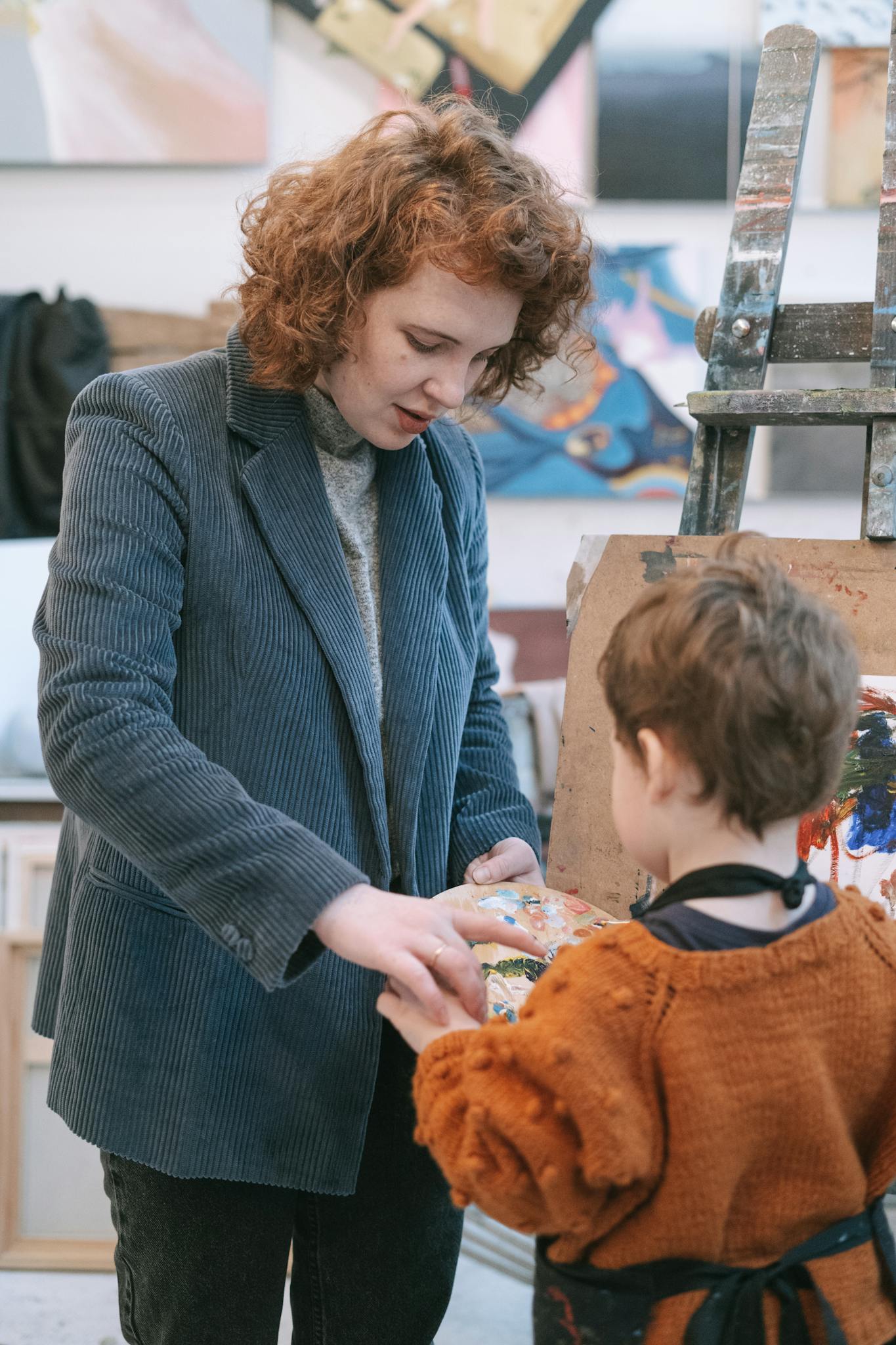 A mother and son engaged in a creative painting session inside an art studio, showcasing vibrant teamwork.